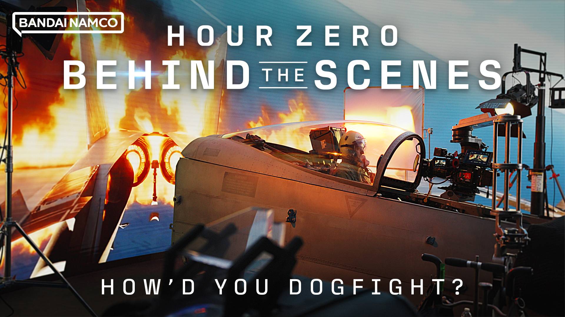 Bandai Namco Hour Zero behind-the-scenes shot of pilot in fighter jet cockpit with camera rig and explosion backdrop