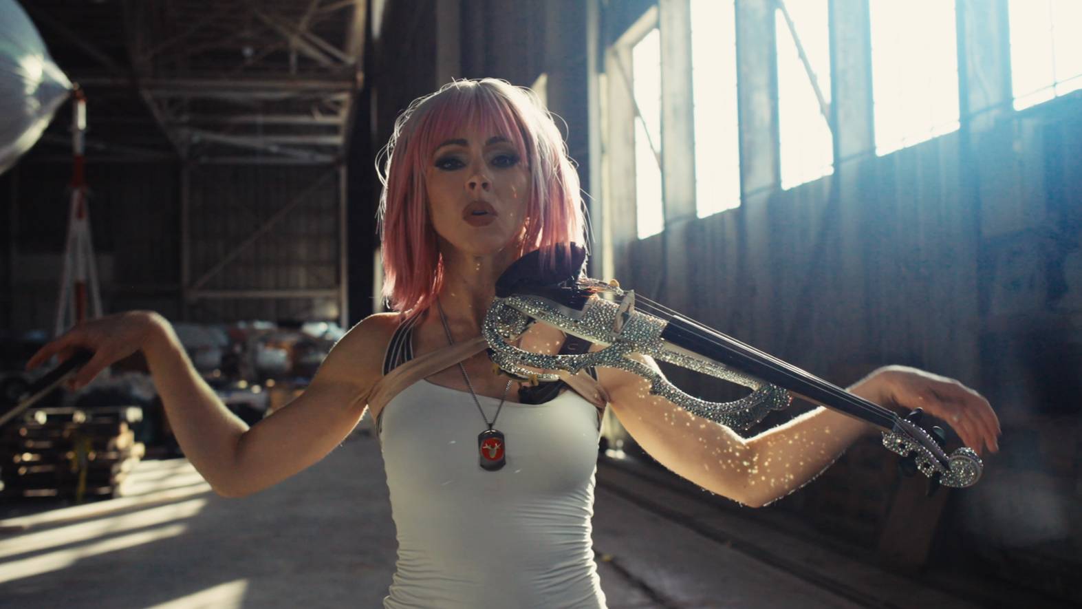 Lindsey Stirling as Tasha Severskaya playing her jeweled violin in a sunlit hangar in ACE COMBAT 8 music video